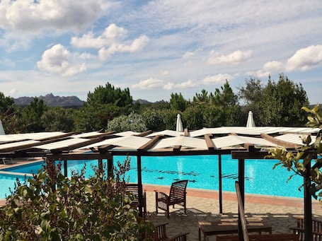 Una piscina al aire libre de temporada, sombrillas