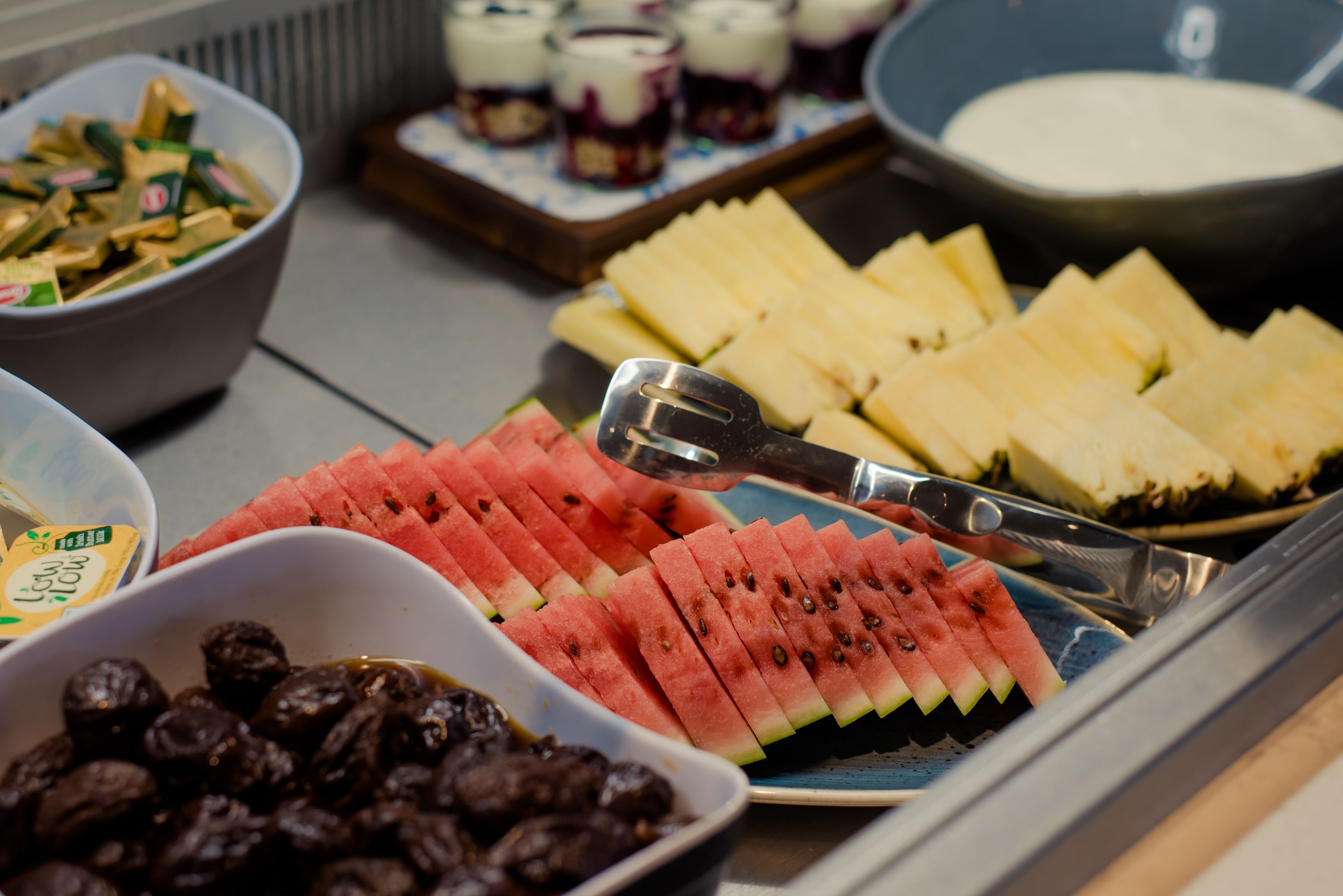 A buffet with various food items including watermelon, cheese, and nuts.