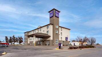 A Sleep Inn building with a central tower, multiple windows, and a parking lot.