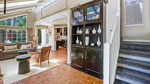 A spacious living area with a sofa, coffee table, and a cabinet with vases.