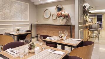 A dining area with tables set for two, featuring placemats, cutlery, and glasses.