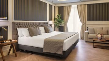 A modern bedroom with a large bed, a sofa, a coffee table, and a nightstand.