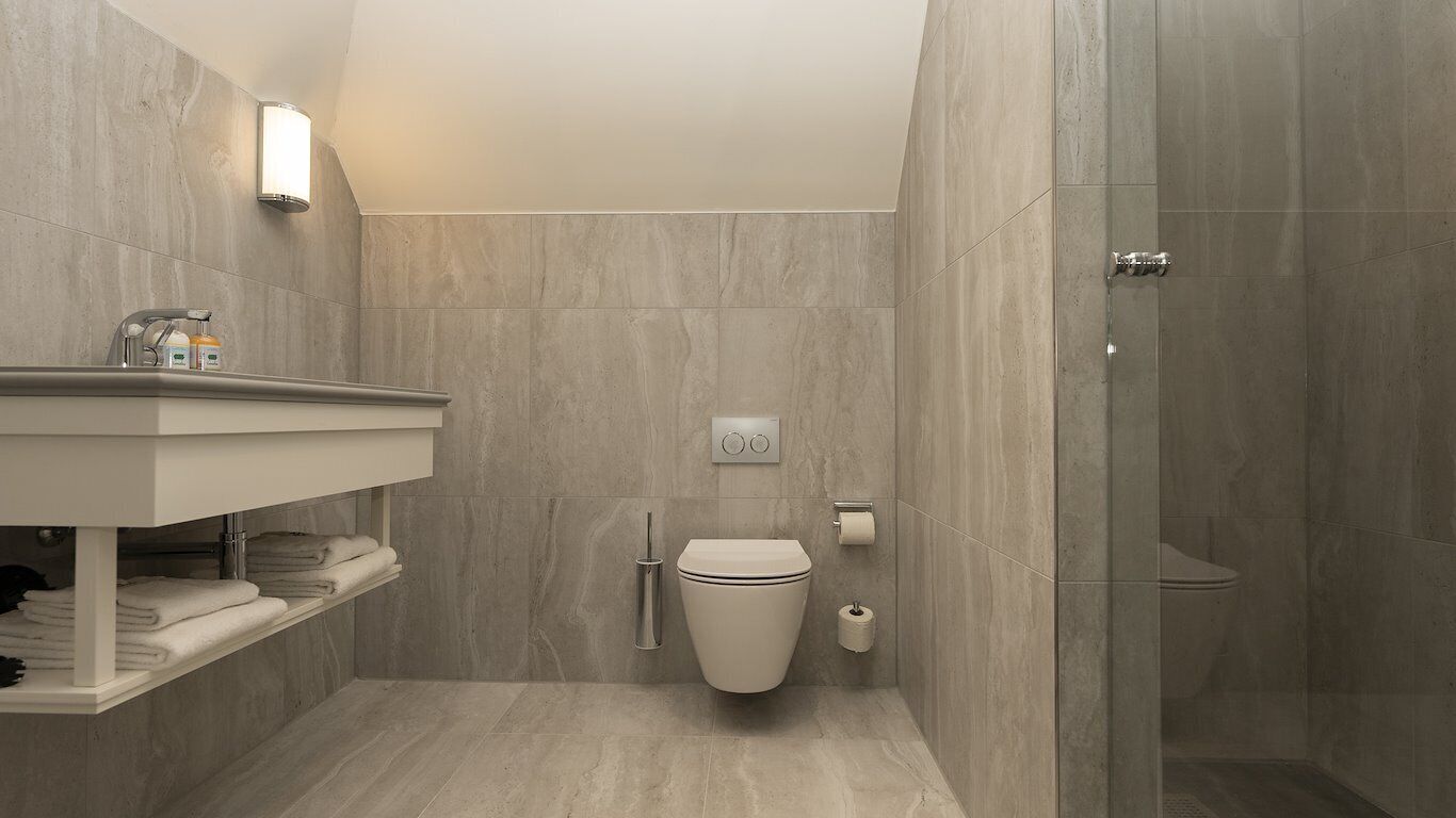A modern bathroom with a shower, toilet, and vanity.