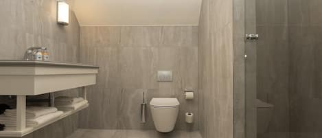 A modern bathroom with a shower, toilet, and vanity.