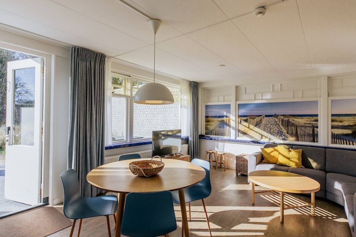 Een moderne woonkamer met een bank, twee stoelen, een salontafel en een televisie.