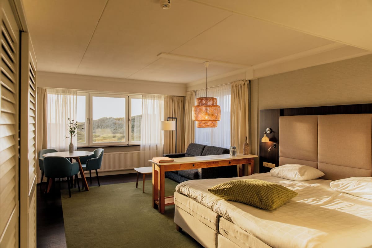 Een hotelkamer met een bed, een bureau, een stoel en uitzicht op de omgeving.