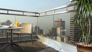 A rooftop terrace with a table and chair, a potted plant, and a city view. - Lan Kwai Fong Hotel @ Kau U Fong by Dorsett Hotels (Hong Kong)