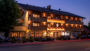 Um hotel com vários andares, área de estar externa e estacionamento.