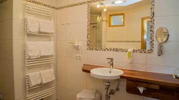 A bathroom with a white sink, a mirror, and a towel rack.