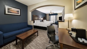 A hotel room with a sofa, a bed, a desk with a coffee maker, and a TV. - Best Western Plus Lake Dallas Inn & Suites (Lake Dallas)
