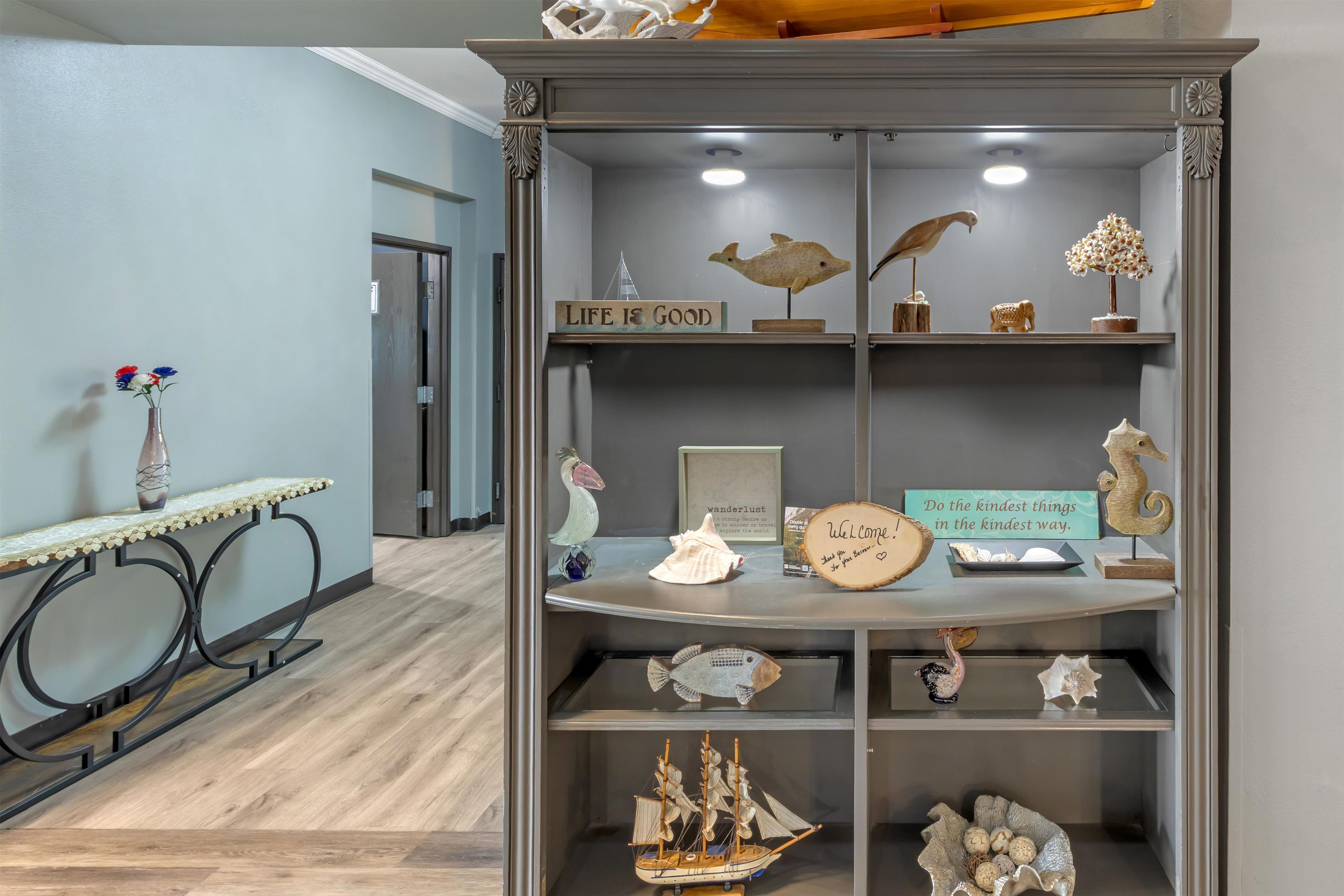 Une pièce dans laquelle se trouve un meuble en bois servant à exposer divers objets décoratifs.
