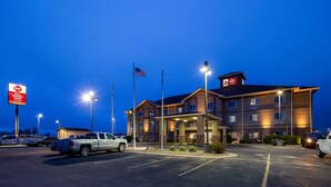 Un hotel Best Western Plus con un parcheggio, diversi edifici e una bandiera.