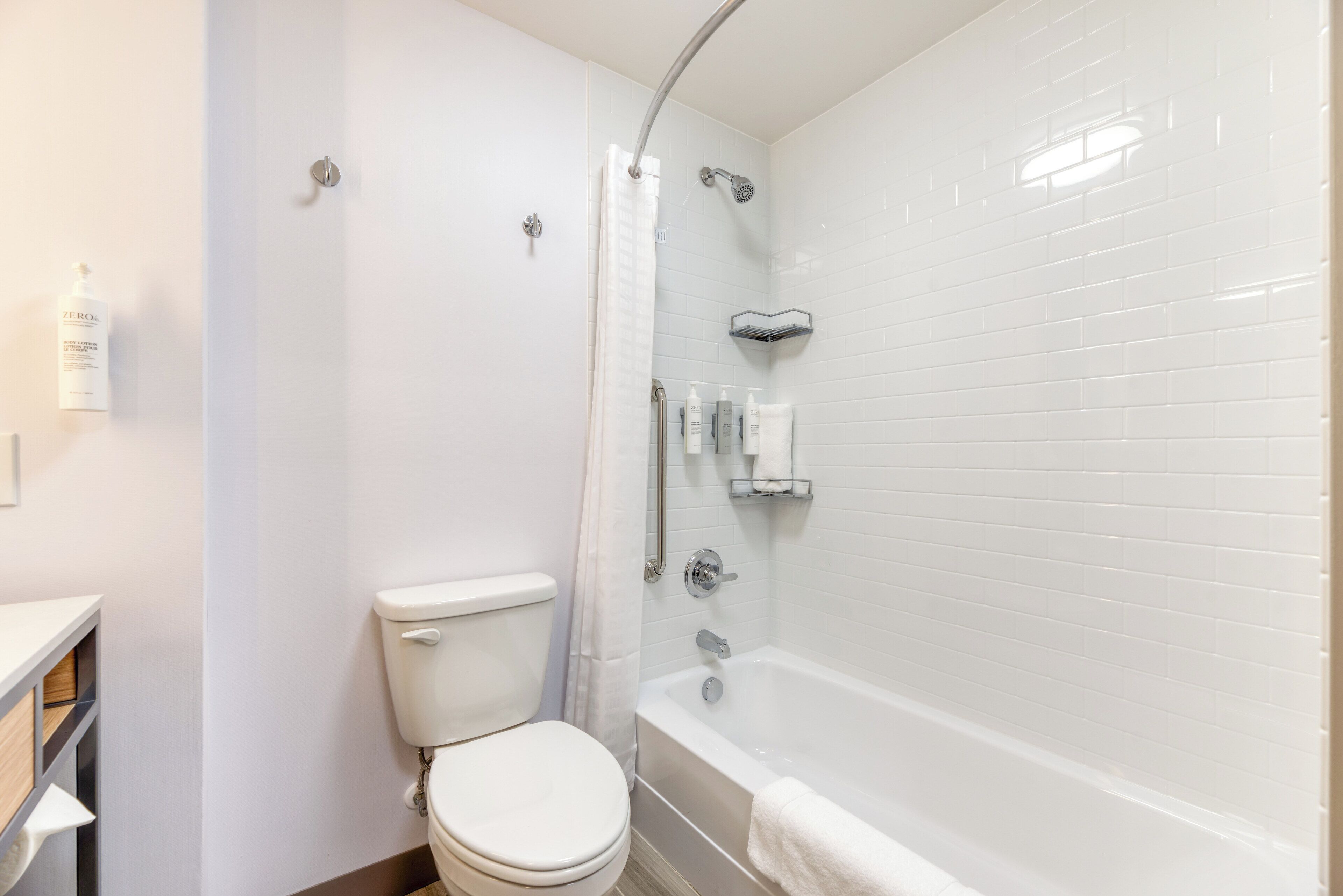Een moderne badkamer met toilet, douche en bad.