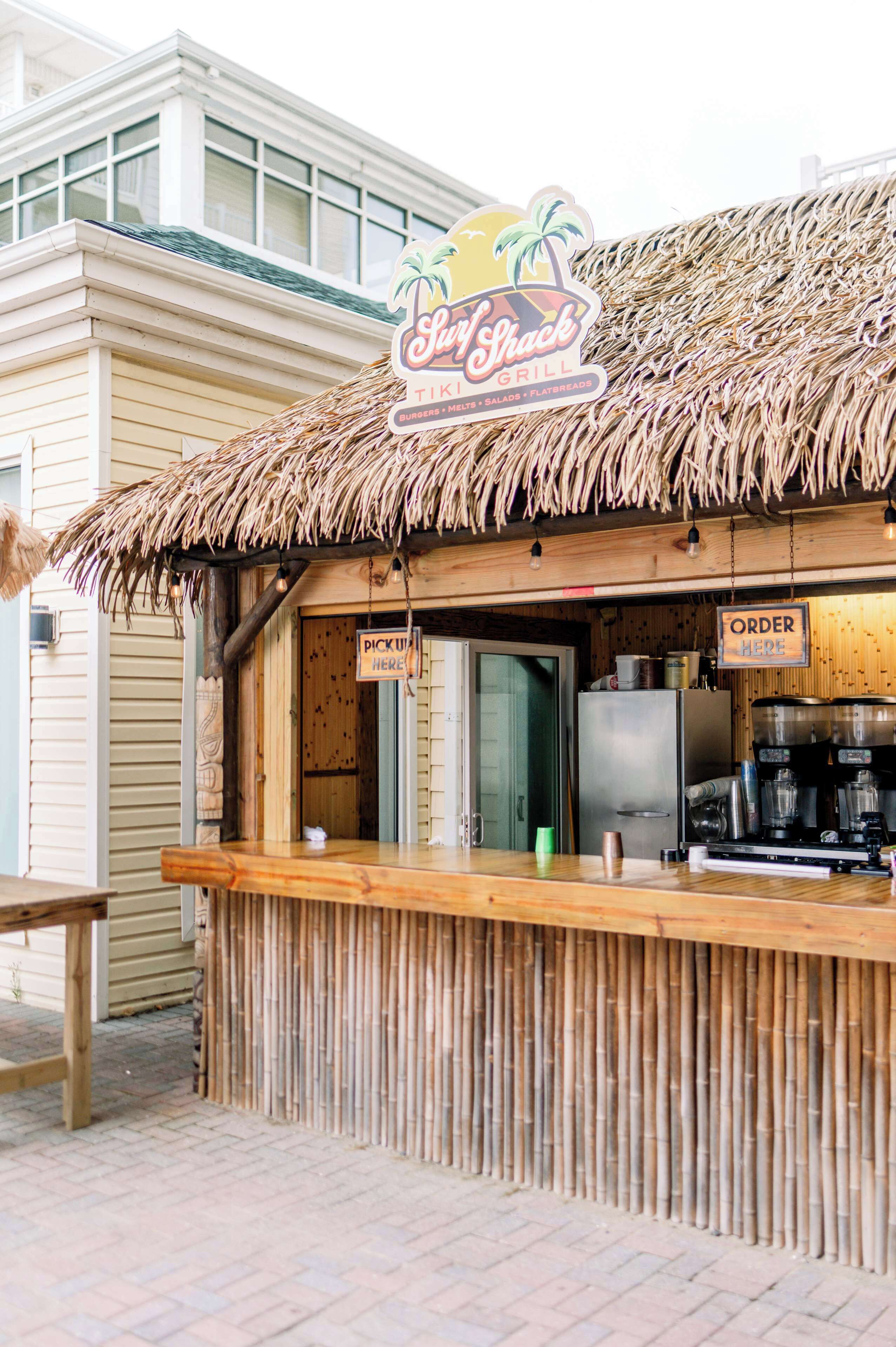 A tiki bar with a thatched roof, a sign reading "Sully Crack Tiki Grill," and a counter with a sign that says "ORDER HERE."