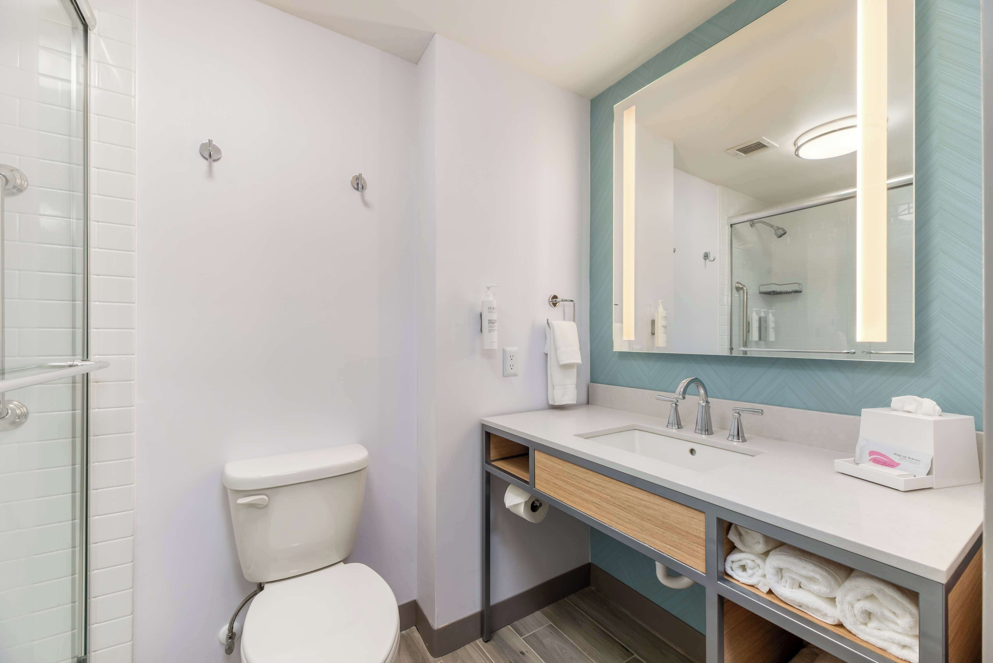 A modern bathroom with a toilet, sink, and shower.