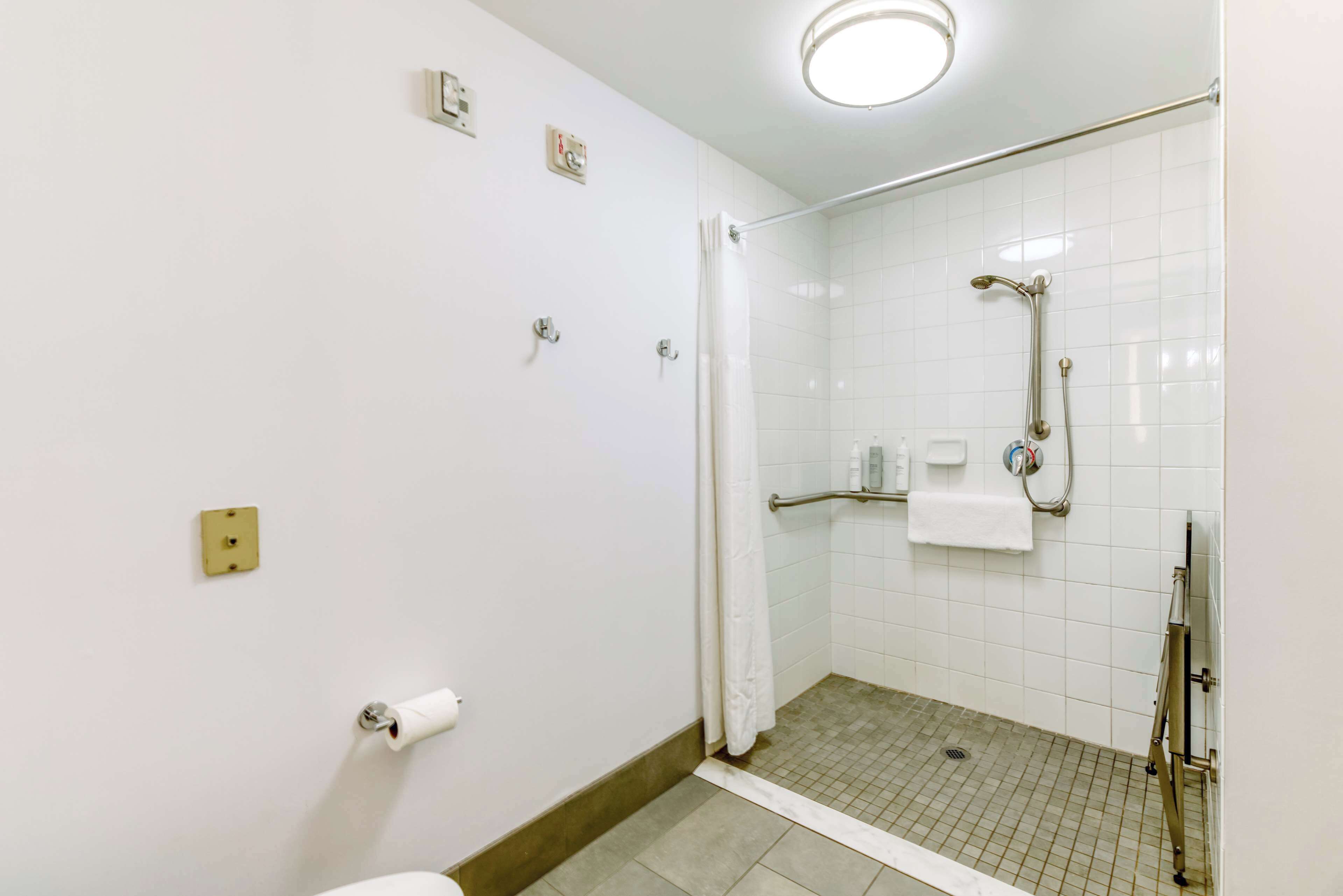 Ein kleines, sauberes Badezimmer mit Dusche, Toilette und Handtuchhalter.