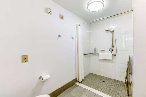 A small, clean bathroom with a shower, toilet, and a towel rack.