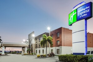Un hotel Holiday Inn Express & Suites con diseño arquitectónico moderno, que cuenta con una señalización llamativa y un estacionamiento.