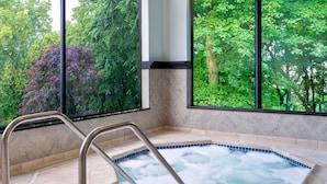 A hot tub with a view of trees through large windows. - Hampton Inn Danbury (Danbury)