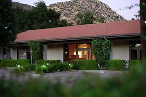 Un edificio con tetto in tegole rosse, ampie finestre e un giardino curato.