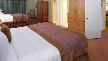 Habitación de hotel con dos camas, un armario y un espejo.