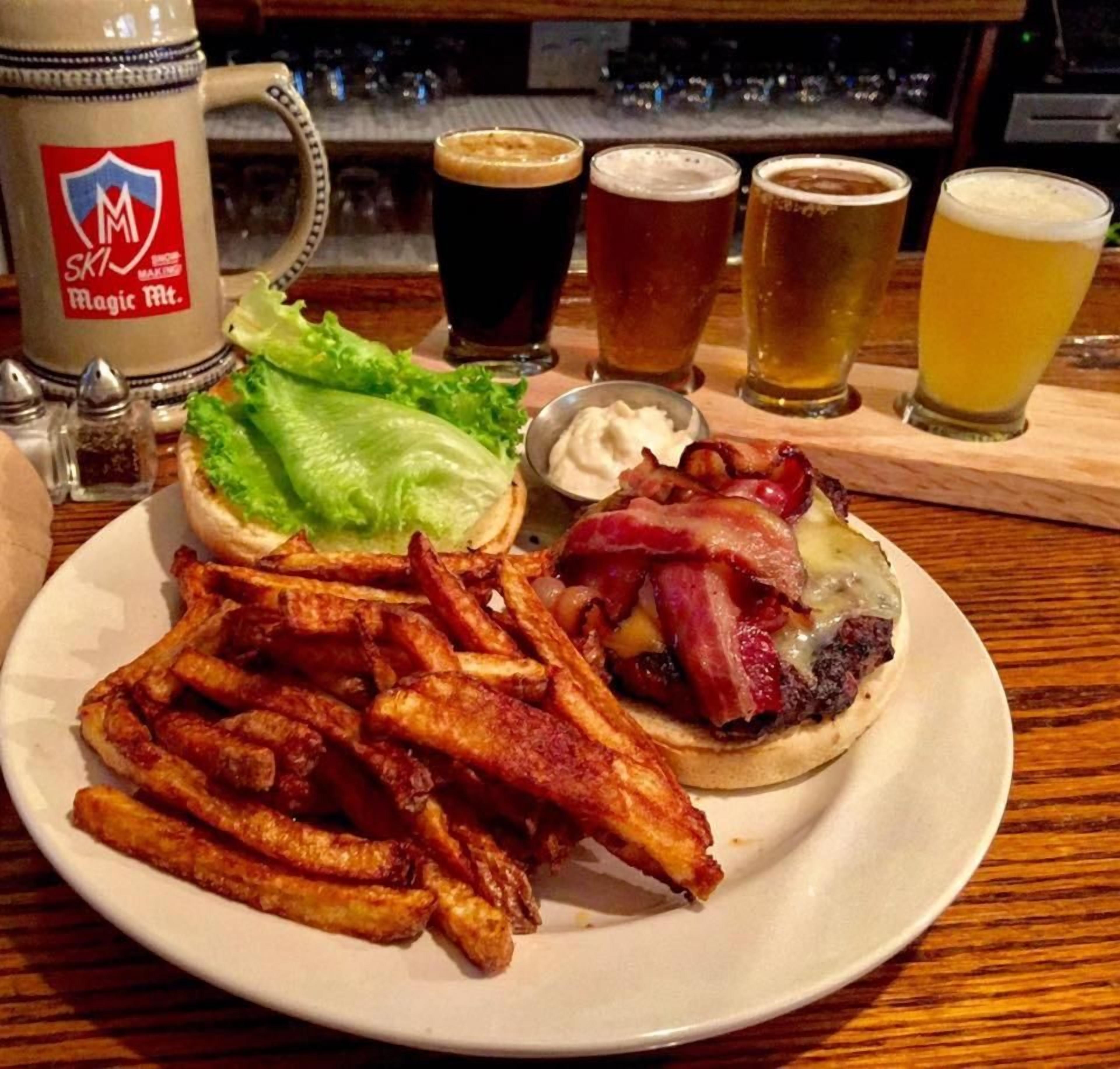 En tallerken med en burger, pommes frites og et drikkelse.