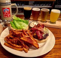 A plate with a burger, fries, and a drink.
