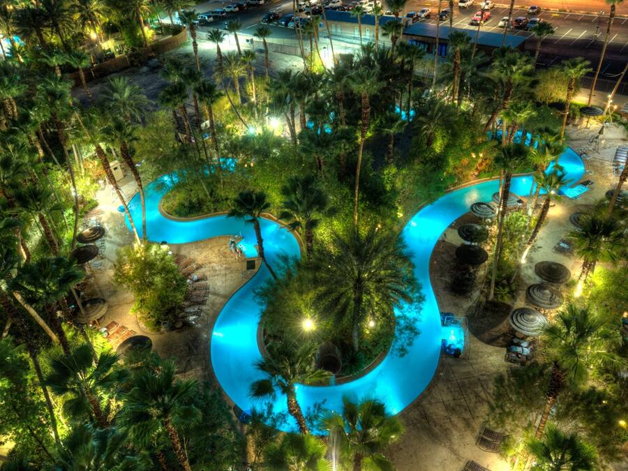 Una piscina al aire libre, sillones reclinables de piscina