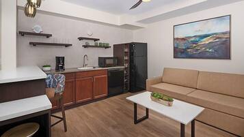 Un espacio habitable compacto con kitchenette, comedor y sofá.
