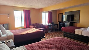 A hotel room with two beds, a TV, a desk, and a chair.