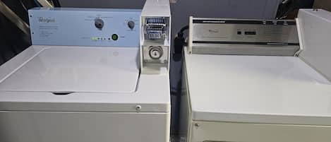 Two stacked Whirlpool washers with control panels, one with a blue panel and one with a silver panel.