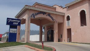 Entrada del hotel Flamingo Inn, con un letrero que indica habitaciones con jacuzzi y disponibilidad.