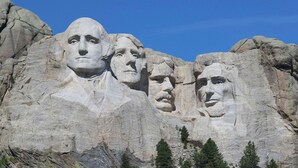 A large rock formation with carved faces. - Magnuson Grand Rushmore View (Keystone)