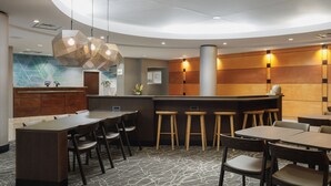 A modern hotel lobby with a reception desk, bar area, and seating arrangements. - SpringHill Suites by Marriott Knoxville at Turkey Creek (Knoxville)