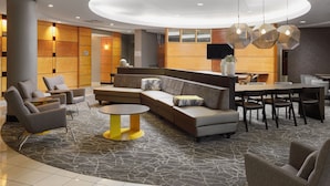 A modern lobby with a curved seating area, a round table, and a dining setup. - SpringHill Suites by Marriott Knoxville at Turkey Creek (Knoxville)