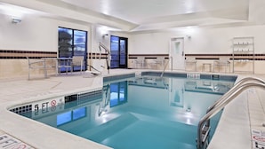 A hotel pool area with a clear pool, safety signs, and a view of the outside. - SpringHill Suites by Marriott Knoxville at Turkey Creek (Knoxville)