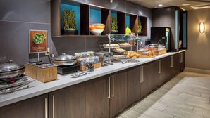 A buffet setup with various food items and a salad bar.