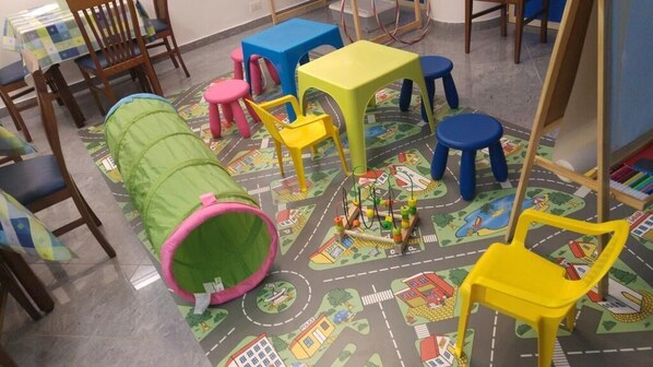 Un área de juegos infantiles con muebles coloridos y un tapete de juego.