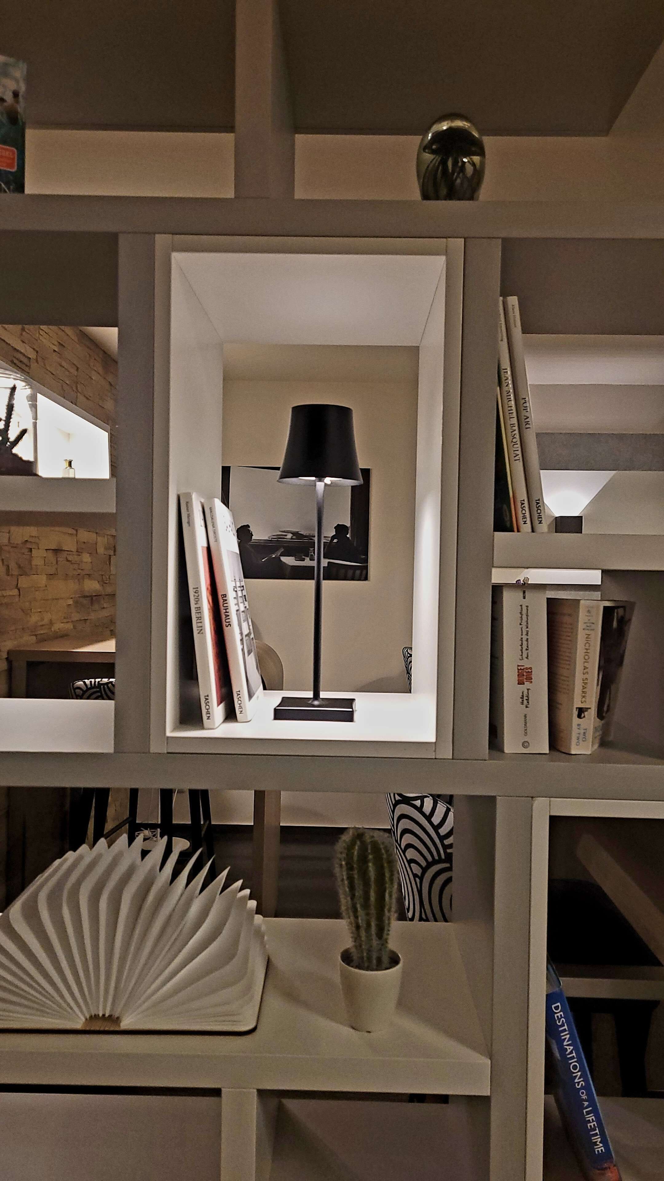 A bookshelf with a lamp, books, and decorative items.