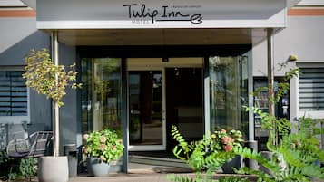 The entrance to a hotel with a sign reading 'Tulip Inn Frankfurt Airport'.