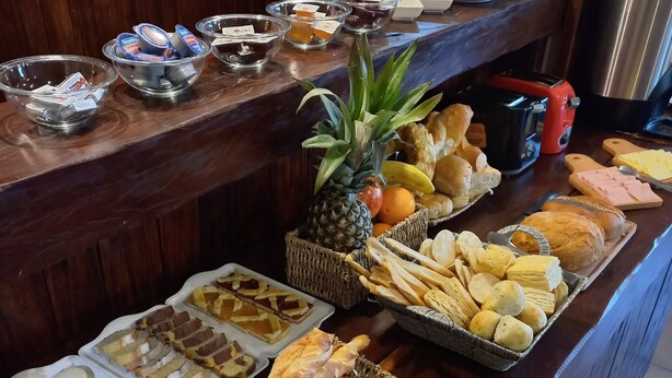 Ein reichhaltiges Buffet mit verschiedenen Speisen, darunter Brot, Gebäck und Obst.