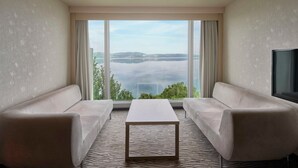 A hotel room with a large window offering a view of a lake and distant hills. There are two sofas and a small table in the center. - Richmond Nua Wellness -Spa - Adults Only (Sapanca)