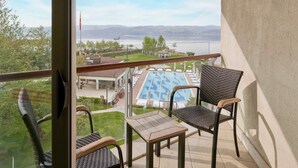 A balcony with wicker chairs and a small table, overlooking a pool and a view of a lake and mountains. - Richmond Nua Wellness -Spa - Adults Only (Sapanca)