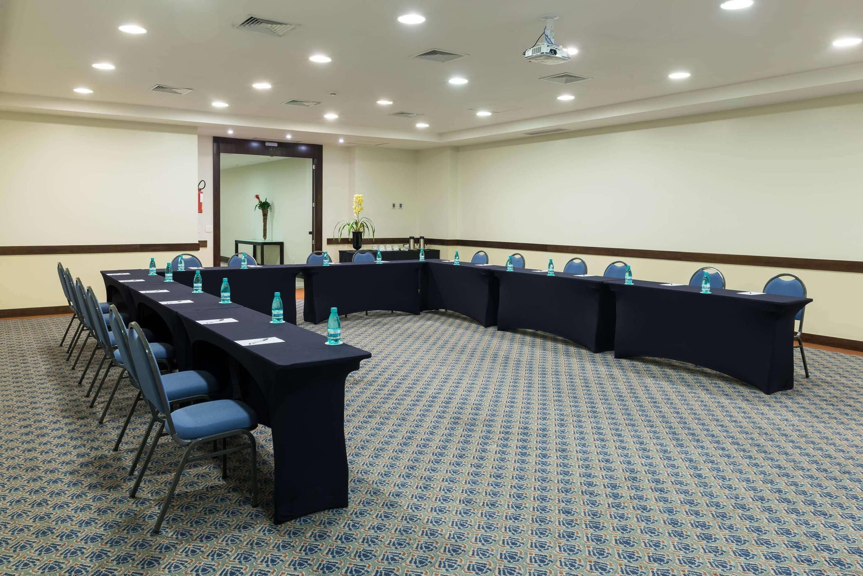 A conference room with a long table, chairs, and water bottles.