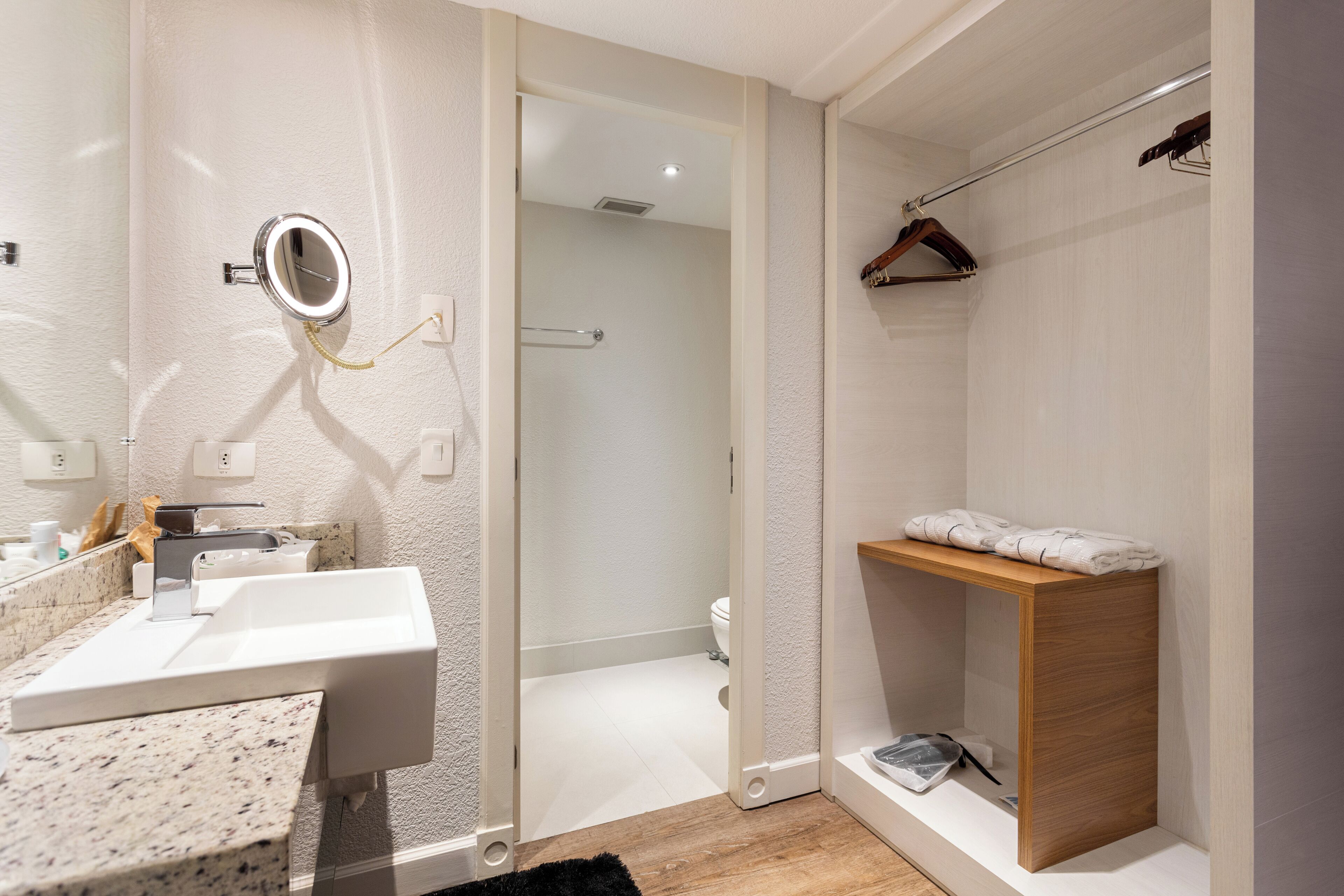 A modern bathroom with a sink, mirror, and shower area.