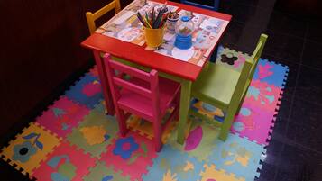 Children can play and create at this fun play area with a table, chairs, and colorful play mat.