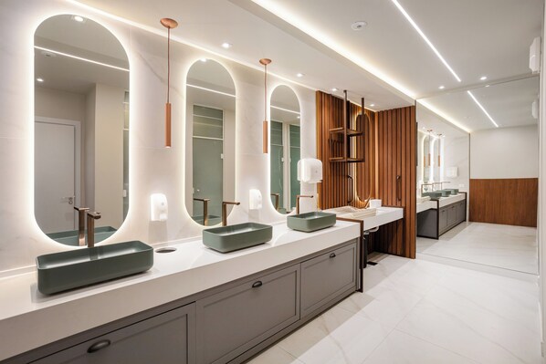 Une salle de bain moderne avec un long meuble-lavabo, deux vasques et un grand miroir.