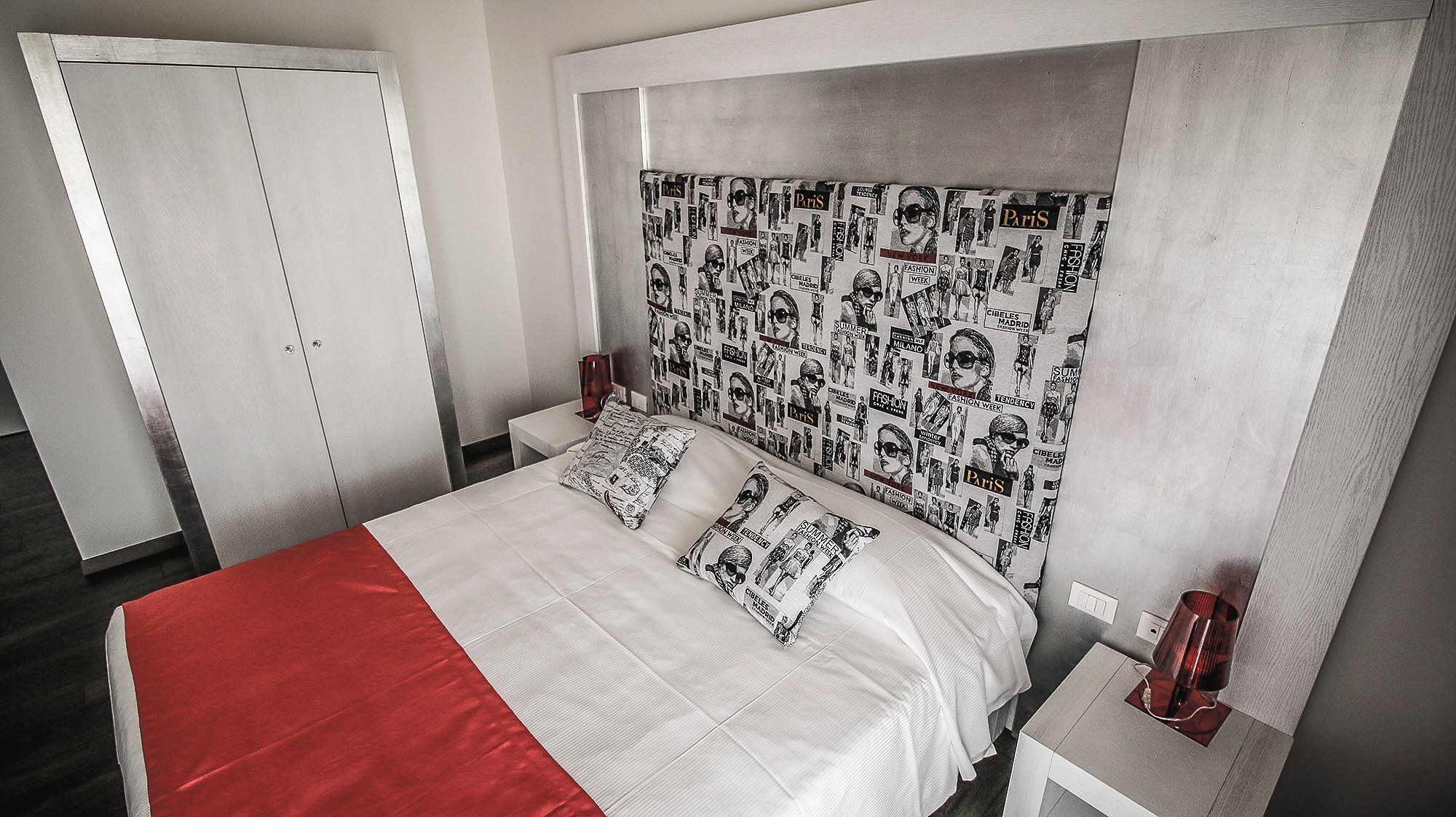 A bedroom with a bed, nightstands, and a wardrobe.
