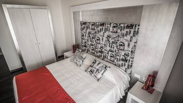 A bedroom with a bed, nightstands, and a wardrobe.