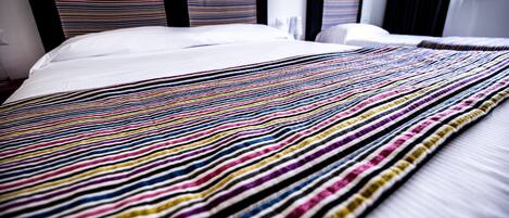 A bed with a striped blanket and a white pillow.